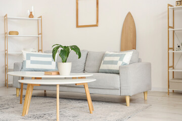 Interior of living room with sofa, tables and surfboard