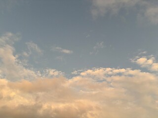 calm sky photo with soft and thin clouds golden light of the sun, light and shadow on the clouds create texture, bright blue sky calming background. Suitable for nature, tranquility, weather, freedom