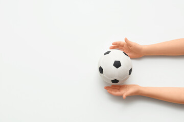 Fototapeta premium Child's hands with soccer ball on white background