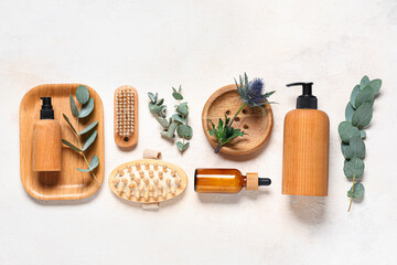 Composition with cosmetic products, spa accessories and eucalyptus branches on light background
