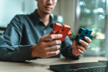 Businessman is hands hold puzzle and join together in a jigsaw puzzle. Teamwork, Partnership,...