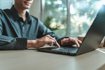 Businessman is hand working and typing on laptop. Business, corporate and finance concept.