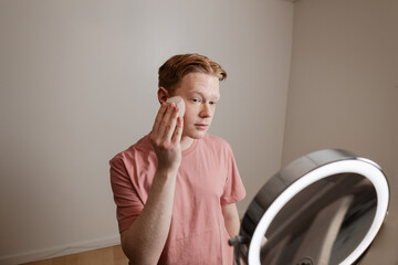 A Medium Shot Of A Young Man Applying Foundation Skincare Makeup Routine
A young man applies...
