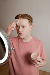 A Vertical Medium Shot Of A Man Applying Powder Makeup Mirror Beauty Routine
A young man applies...