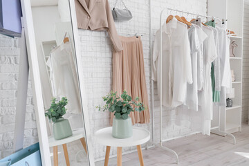 Interior of stylist's studio with clothes rack, pin board and mirror