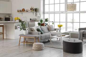 Interior of kitchen with counters, sofa and daffodils in vases