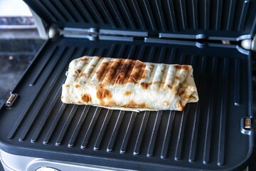 Close-up of a delicious shawarma wrap held in hand