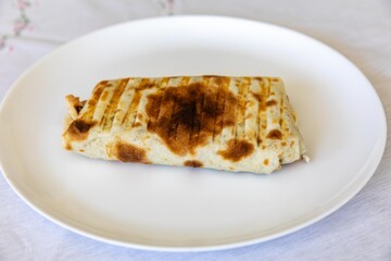 Close-up of a delicious shawarma wrap held in hand