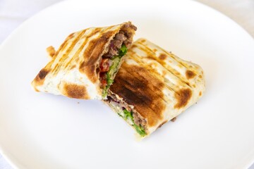 Close-up of a delicious shawarma wrap held in hand