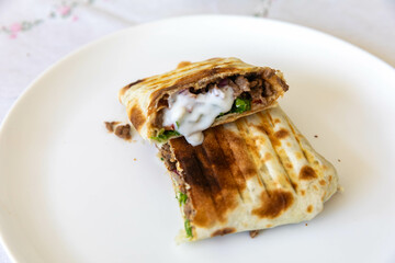 Close-up of a delicious shawarma wrap held in hand