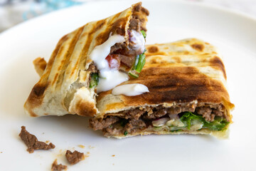 Close-up of a delicious shawarma wrap held in hand