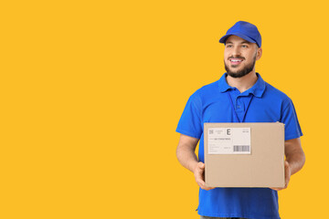 Male courier with parcel on yellow background