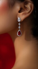 Elegant teardrop earrings with red gemstones and sparkling diamonds.