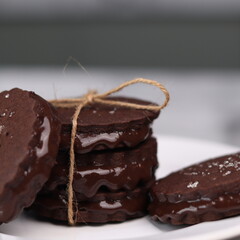 chocolate cookies arranged on a white plate with a marble table background
