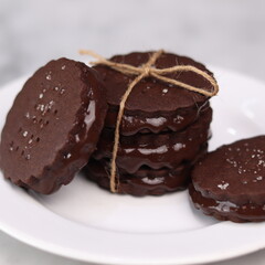 chocolate cookies arranged on a white plate with a marble table background