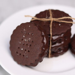 chocolate cookies arranged on a white plate with a marble table background