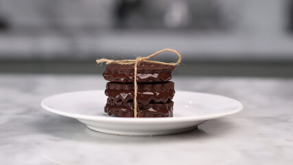 chocolate cookies arranged on a white plate with a marble table background