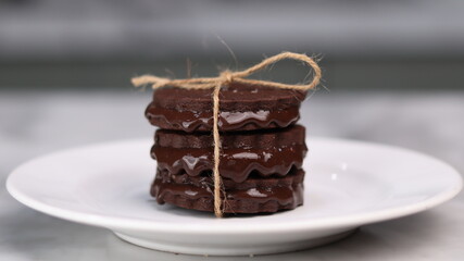 chocolate cookies arranged on a white plate with a marble table background