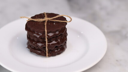 chocolate cookies arranged on a white plate with a marble table background