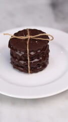 chocolate cookies arranged on a white plate with a marble table background
