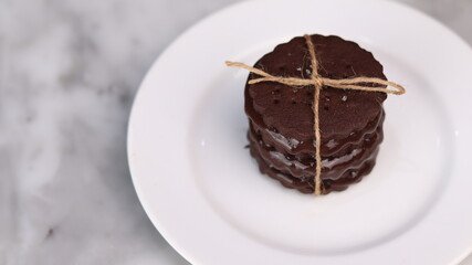 chocolate cookies arranged on a white plate with a marble table background