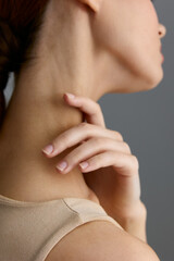 Beauty woman with delicate skin and graceful neck pose, showcasing natural elegance and subtle fashion style in soft neutral tones close-up.