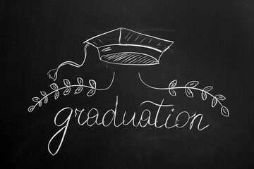 Word GRADUATION with drawn mortar board and wreath on blackboard
