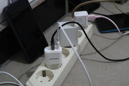 Jepara, 22 Juni 2025  - smartphone charger plugged into an electrical terminal
