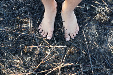 Feet Standing on Burnt Straw Field