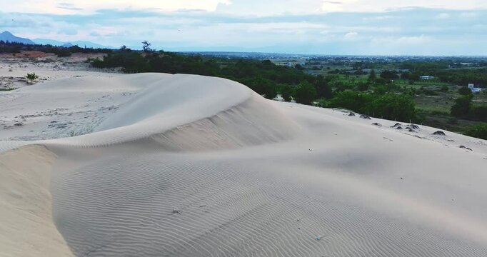 Ripples wave lead to peak of sand dunes under sunny blue cloud sky in Nam Cuong, Phan Rang, Viet Nam. Natural desert and sand dunes landscape