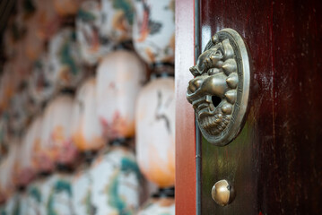 A Chinese Door with a Decorative Knocker and Traditional Lantern