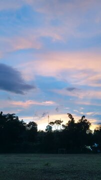The beauty of sunrise on a field with mountains and clouds in the background
