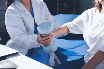 Unrecognizable uses blue hand weight during physical therapy session