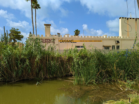 Restaurant Canyamel castellated building in El Palmar by Albufera Natural Park lush green water canal with reeds in Valencia, Spain. Traditional mediterranean cuisine tourism, spanish paella eatery. 