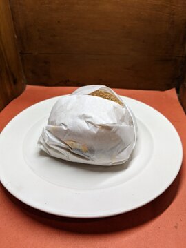 Mini burger on a white plate, with a wood and orange background