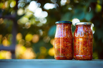 Home preservation. Vegetable salad in a glass jar on a wooden table. Natural green background with smooth bokeh. Healthy food concept. Vegetables from the garden.