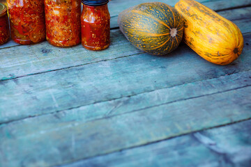 Home preservation. Vegetable salad in a glass jar on a wooden table. Natural green background with smooth bokeh. Healthy food concept. Vegetables from the garden.