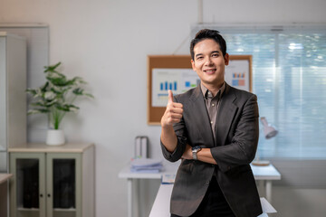 Fototapeta premium A man in a suit is giving a thumbs up in front of a bulletin board with graphs o
