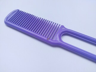 Close up view of purple plastic comb isolated on white background.