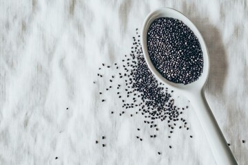 Black Seeds in Spoon on White Linen Cloth Background
