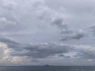 clouds over the sea The sky over the sea on a cloudy day has large clouds floating in the sky. The atmosphere is gray.