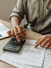 Calculating expenses: person using calculator and documents to manage finances.