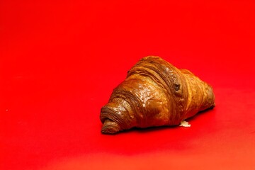 Buttery croissant on a vibrant red surface