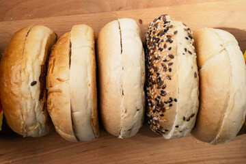Closeup view of collection of bagel breads with various kind on wooden board. Top view