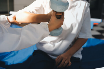 Unrecognizable uses blue hand weight during physical therapy session