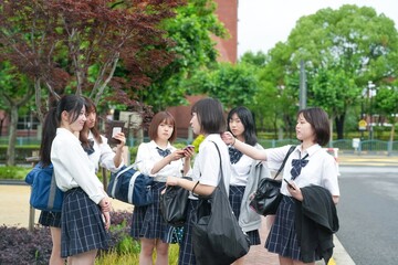 In early June in Pudong, Shanghai, six Japanese high school girls in summer uniforms gather in front of their school, chatting and smiling in the warm sun and breeze as they get ready for the day.