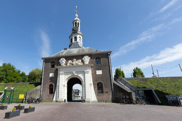 Fototapeta premium The historic Zijlpoort gate in Leiden, Netherlands, a prominent city landmark with its elegant architecture and clock tower, bathed in sunlight.