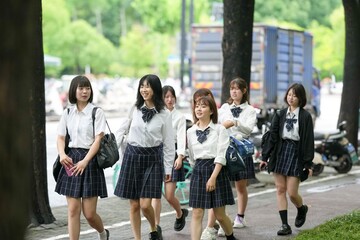 In early June in Pudong, Shanghai, seven Japanese high school girls in summer uniforms walk...