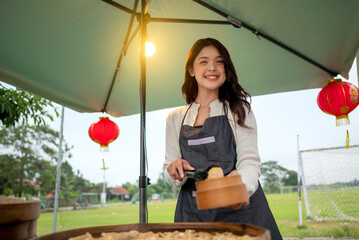 Indonesian southeast chinsese asian female waiter prepare serving food for her customer. A small business on a truck