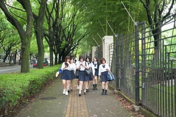 In early June in Pudong, Shanghai, seven Japanese high school girls in summer uniforms walk...